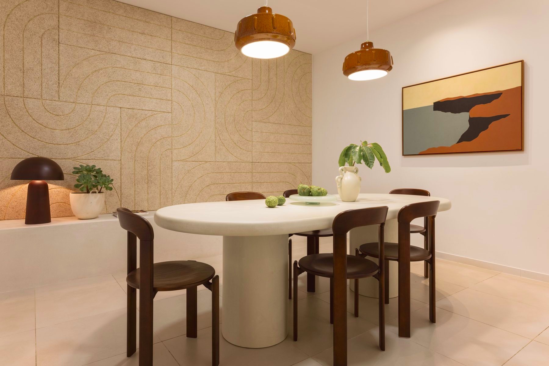 Dining-style meeting room with pendant lights and framed landscape art