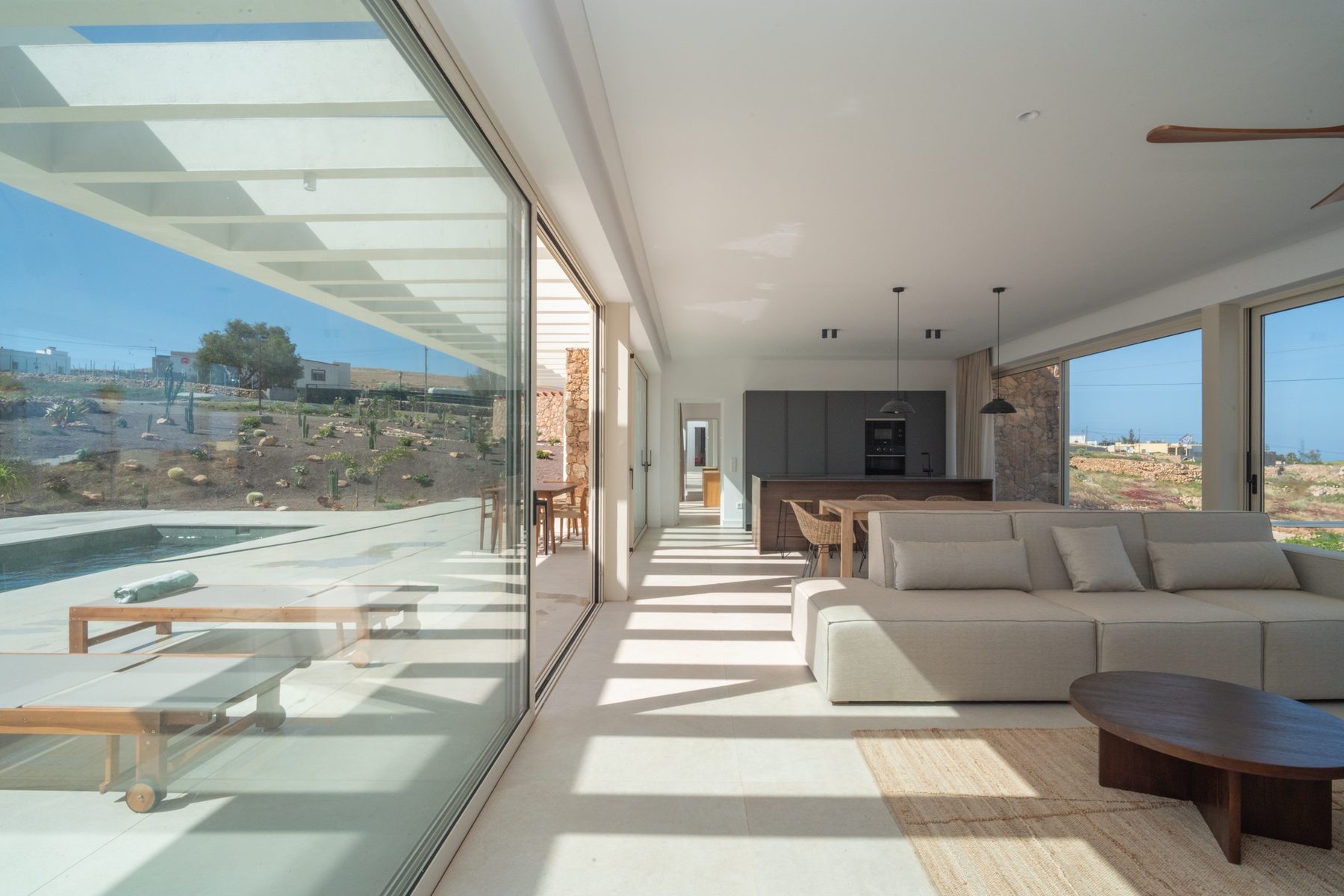Living room with white sofas and sliding doors open to the terrace
