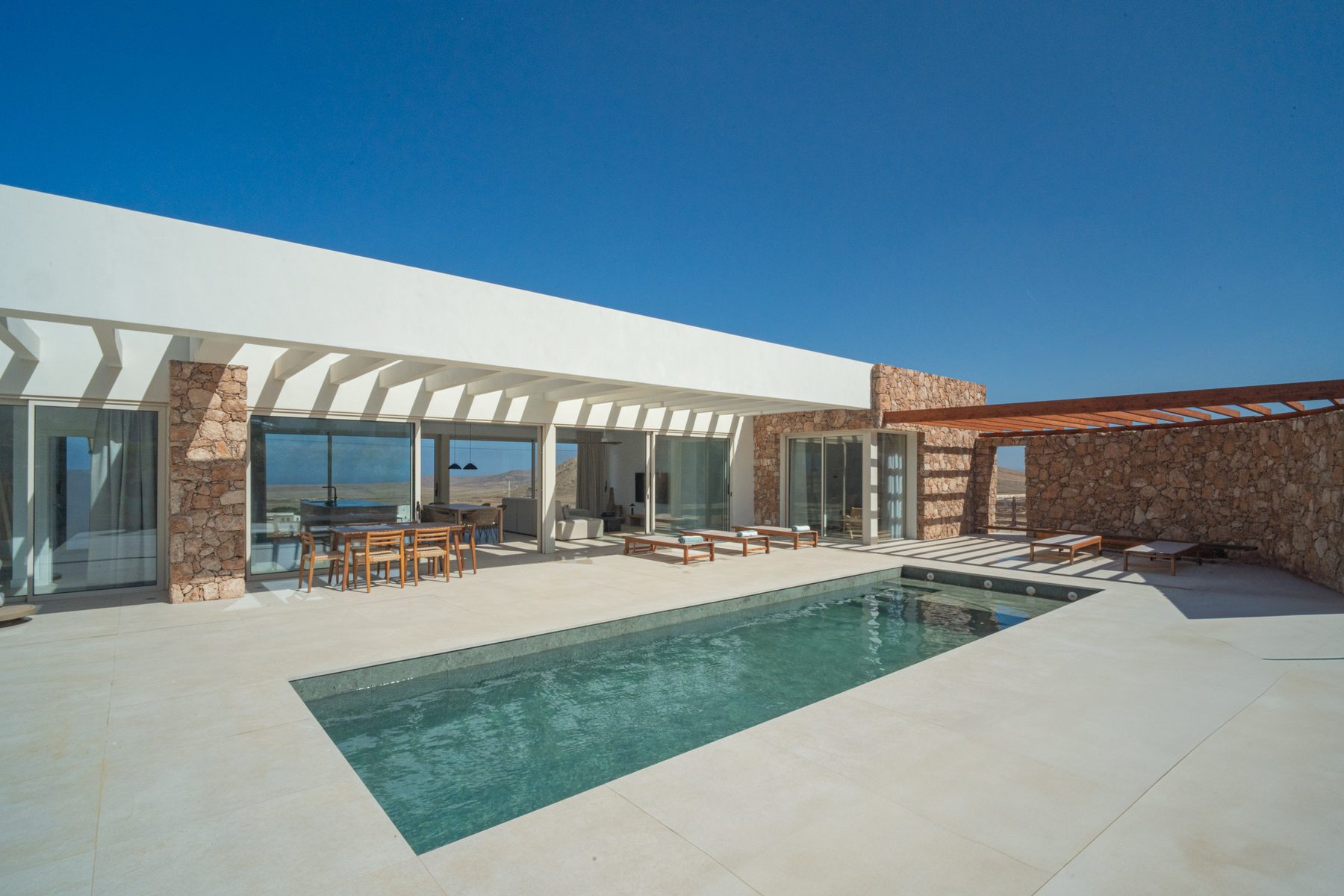 Villa exterior with a stone accent wall and pool terrace
