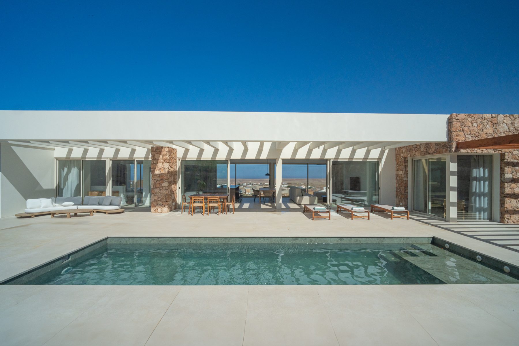Kitchen and living room beneath a wood pergola ceiling