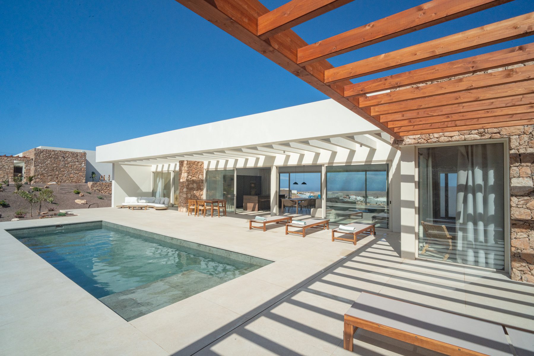 Living room with sliding glass doors open to the pool terrace
