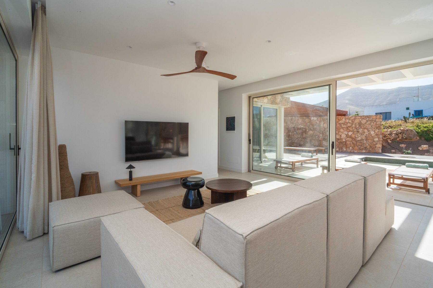 Kitchen island with bar stools beneath pendant lighting