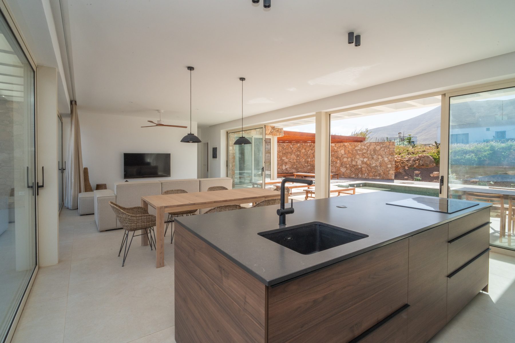 Kitchen and dining area beneath pendant lights, mountain view beyond