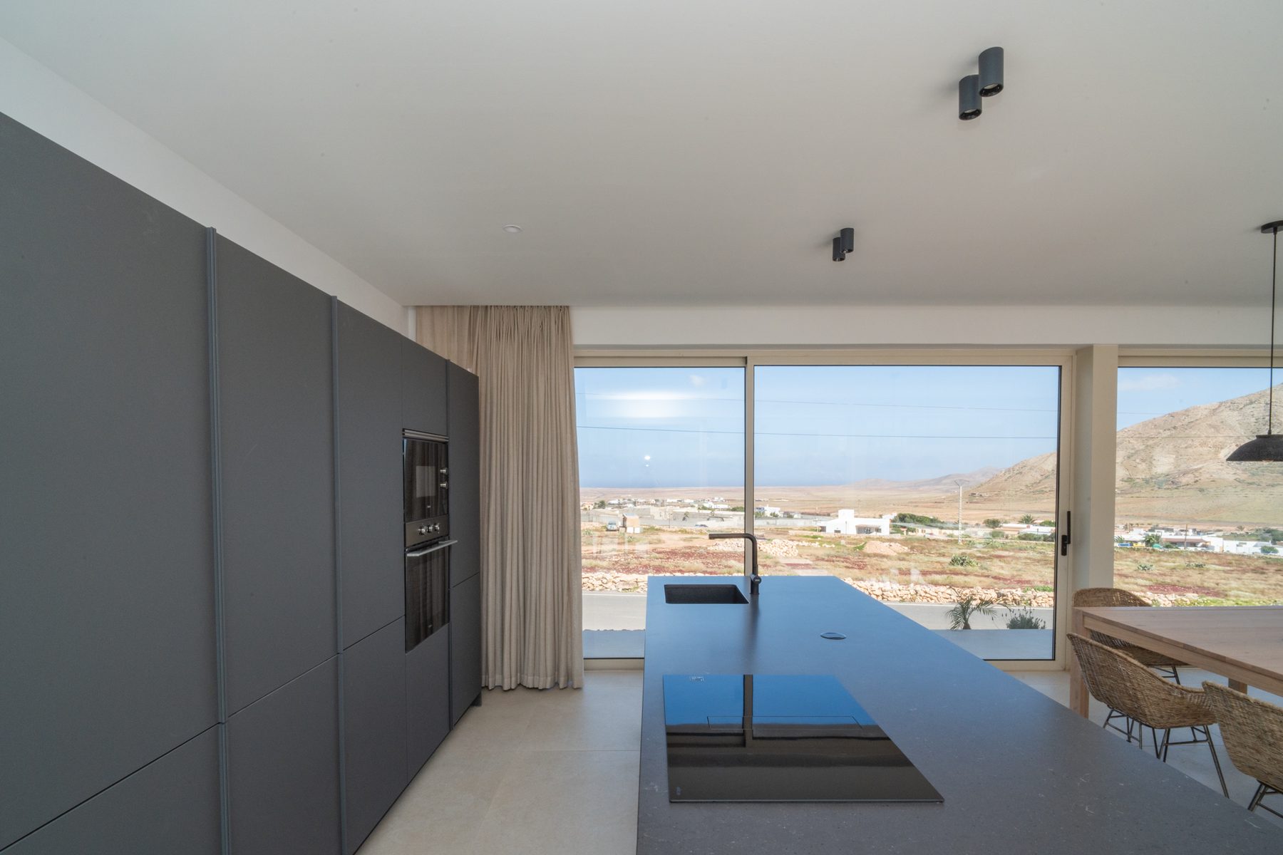 Living room and dining area connected by glass doors, view to the garden